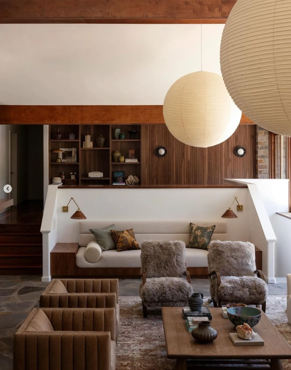 Mid-Century Living woom with wood cabinetry, white sofa, leather accent chairs and wood coffee table